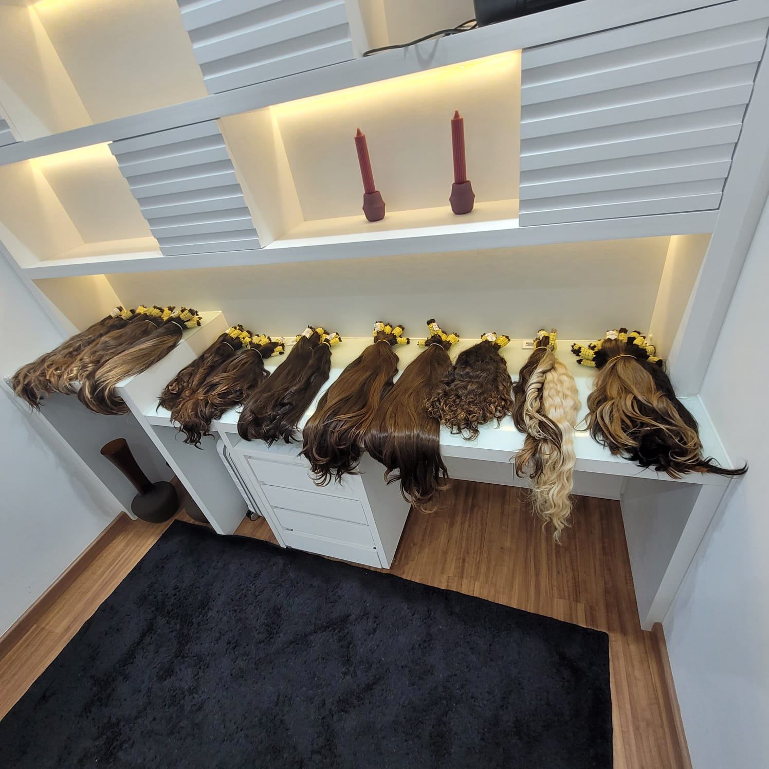 Bundles of synthetic hair extensions arranged on a white counter.
