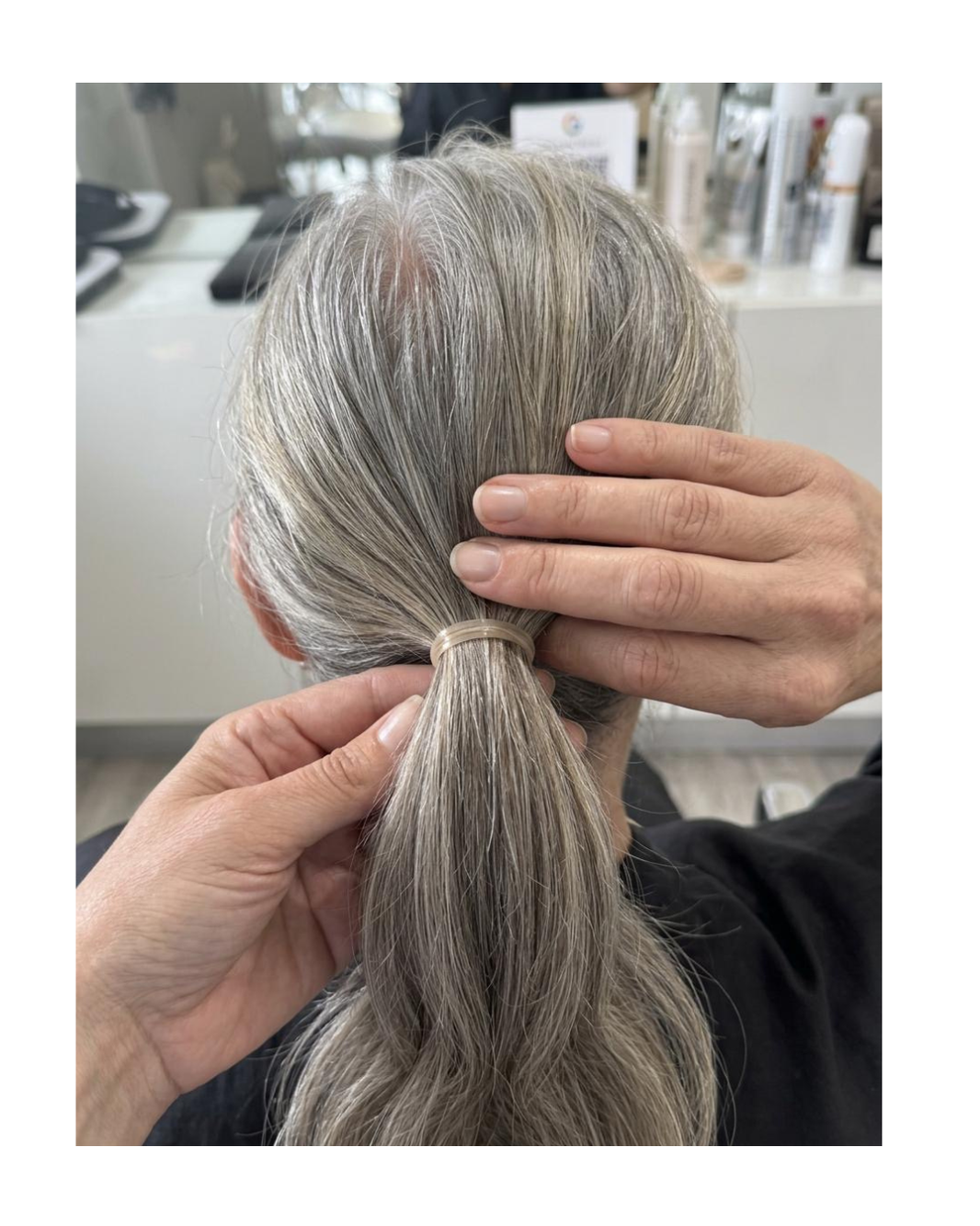 Woman demonstrating reduced ponytail thickness caused by hair thinning.