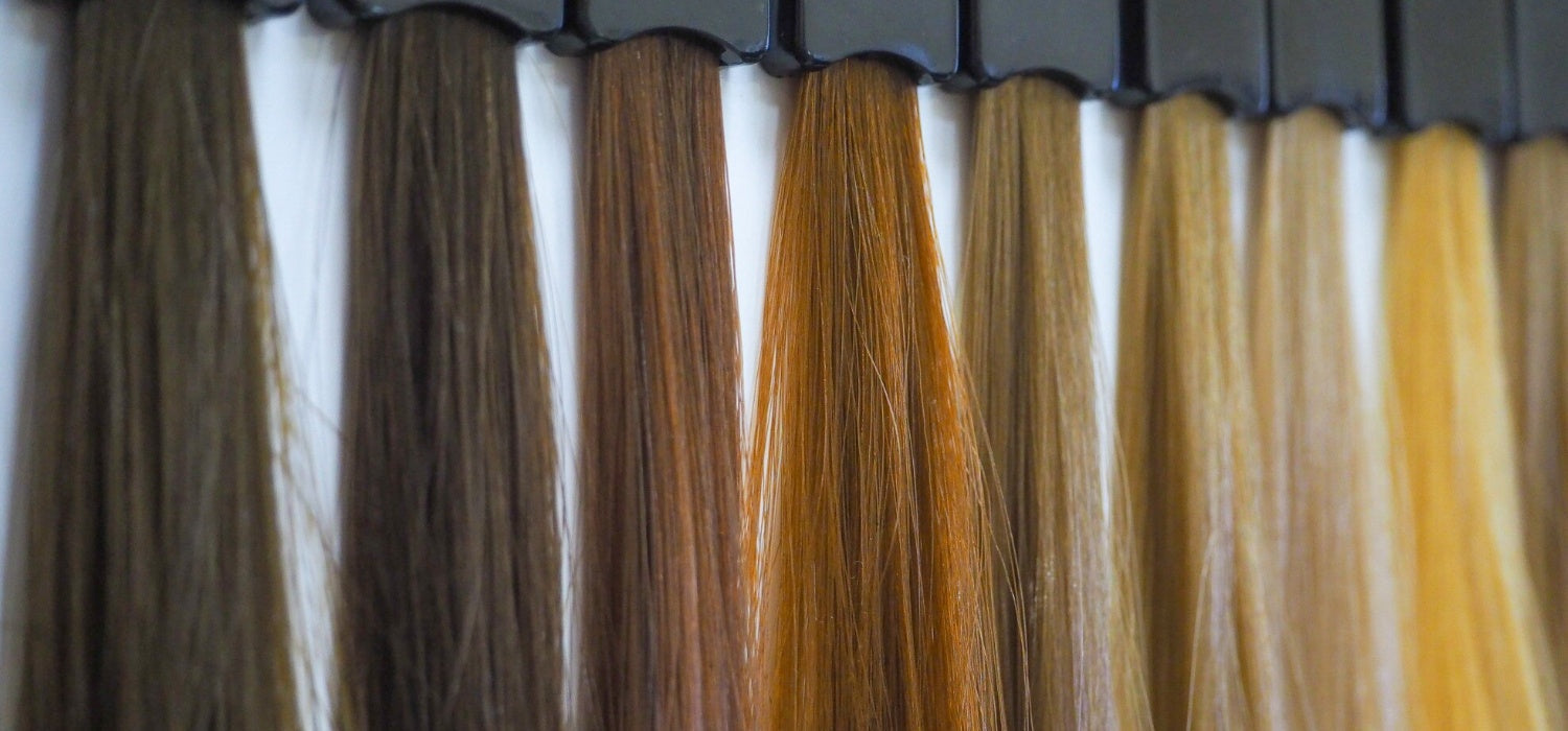Hair extension color swatches displaying a range of shades from dark brown to blonde, used for matching and customizing natural-looking hair extensions.