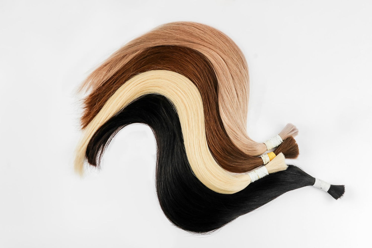 Natural human hair bundles in blonde, brown, and black shades displayed on a white background.