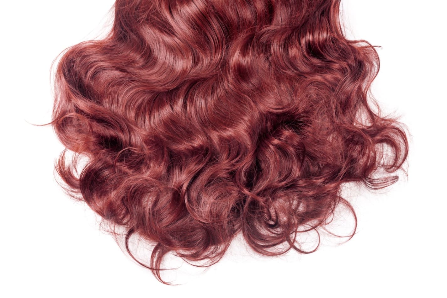 A close-up image of a rich, curly, red wig showcasing the natural wave and texture of the hair.