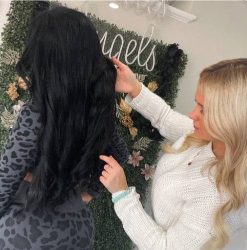 hair stylist working with hair extensions at Noelle Salon Boston